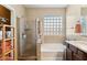 Bathroom featuring a glass shower, soaking tub, glass block window for privacy, and natural light at 4960 S Huachuca Pl, Chandler, AZ 85249