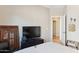 Neutral bedroom with television and decor plus an adjacent view into hall and doorway at 4960 S Huachuca Pl, Chandler, AZ 85249