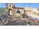 Inviting home with desert landscaping, an arched entry, and a tan stucco exterior at 4960 S Huachuca Pl, Chandler, AZ 85249