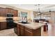 Kitchen with black appliances, tile countertops, island with sink, and open view to the living room at 4960 S Huachuca Pl, Chandler, AZ 85249