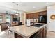 Kitchen with dark wood cabinets, tile backsplash, black appliances, and island with breakfast bar seating at 4960 S Huachuca Pl, Chandler, AZ 85249