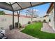 Charming backyard featuring an artificial lawn, covered patio, pavers, and privacy wall at 542 S Higley Rd # 83, Mesa, AZ 85206