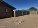 Spacious backyard with gravel, block fence, and a small paved square area at 6308 E Billings St, Mesa, AZ 85205