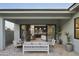 Inviting covered back patio with seating and view of the indoor open-concept living space through sliding doors at 6710 N 9Th Dr, Phoenix, AZ 85013