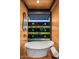 Modern bathroom featuring a soaking tub with unique horizontal slat windows overlooking the surrounding landscape at 7686 E Stagecoach Pass Rd, Carefree, AZ 85377