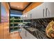 Modern laundry room features sleek black marble counters, stainless steel sink, and ample storage at 7686 E Stagecoach Pass Rd, Carefree, AZ 85377