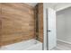 Renovated bathroom with wood-look tile surround and stylish fixtures at 7906 W Catalina Dr, Phoenix, AZ 85033