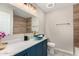 Stylish bathroom with a designer bowl sink, blue vanity, and modern fixtures at 7906 W Catalina Dr, Phoenix, AZ 85033