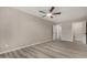 Spacious bedroom featuring light-colored walls, ceiling fan, and two access doors at 7906 W Catalina Dr, Phoenix, AZ 85033