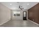 Bright living room features a modern ceiling fan, wood-look vinyl floors and a stylish wood accent wall at 7906 W Catalina Dr, Phoenix, AZ 85033