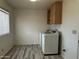 Functional laundry room with modern appliances, wood laminate flooring, and storage at 8235 E Medina Ave, Mesa, AZ 85209