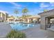 Community pool with covered seating areas, palm trees, and blue sky creating a relaxing resort-style ambiance at 8245 E Bell Rd # 201, Scottsdale, AZ 85260