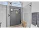 Frameless glass shower showcasing gray patterned tile, built-in shelf and a wooden shower stool. Upscale finishes at 8245 E Bell Rd # 201, Scottsdale, AZ 85260