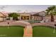 Backyard area featuring a putting green, swimming pool, outdoor kitchen, and desert landscaping at 844 W Beechnut Dr, Chandler, AZ 85248