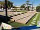 Backyard featuring a Bocce Ball Court, putting green, pond views, patio seating, and palm trees at 844 W Beechnut Dr, Chandler, AZ 85248