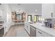 Modern white kitchen featuring stainless steel appliances, a breakfast bar, and unique barstool window at 844 W Beechnut Dr, Chandler, AZ 85248