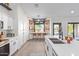 Modern white kitchen featuring stainless steel appliances, a breakfast bar, and unique barstool window at 844 W Beechnut Dr, Chandler, AZ 85248