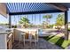 View of the outdoor kitchen and backyard featuring a granite countertop, built-in grill, lake views, and a pergola at 844 W Beechnut Dr, Chandler, AZ 85248