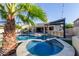 Inviting backyard with a sparkling pool, spa, a lush palm tree and an outdoor bar area at 844 W Beechnut Dr, Chandler, AZ 85248