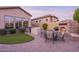 Backyard patio area with outdoor kitchen, stone fireplace and green turf at 8525 E Lynwood St, Mesa, AZ 85207