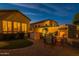 Spacious backyard at dusk with an outdoor kitchen, patio seating, putting green and fireplace at 8525 E Lynwood St, Mesa, AZ 85207