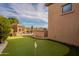 Beautiful backyard featuring a putting green, outdoor kitchen, and stone fireplace for luxurious outdoor living at 8525 E Lynwood St, Mesa, AZ 85207