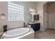 Spacious bathroom featuring a soaking tub, large glass block window, and dark wood cabinets at 8525 E Lynwood St, Mesa, AZ 85207