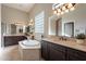 Luxurious bathroom featuring a soaking tub, dark wood cabinets, and beige marble countertops at 8525 E Lynwood St, Mesa, AZ 85207