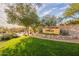 Stonegate community entrance featuring a stone wall, beautiful landscaping, and lush green grass at 8525 E Lynwood St, Mesa, AZ 85207