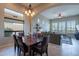 Dining area with dark wood table with seating for six, flowing into the living room with ample natural light at 8525 E Lynwood St, Mesa, AZ 85207