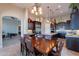 Elegant dining area adjacent to the kitchen features a chandelier and a dark wood dining table with seating for six at 8525 E Lynwood St, Mesa, AZ 85207