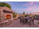 Cozy outdoor fireplace with stone surround and dining set, perfect for enjoying evenings in a serene setting at 8525 E Lynwood St, Mesa, AZ 85207