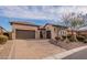 Charming home featuring a three-car garage, stone accents, arched entry, and a paved driveway at 8525 E Lynwood St, Mesa, AZ 85207