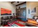 Cozy living room featuring a leather couch, a unique bookshelf, and a bright, multi-colored rug at 8525 E Lynwood St, Mesa, AZ 85207