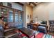 Comfortable living room with a large bookshelf, leather chairs, and a colorful striped rug at 8525 E Lynwood St, Mesa, AZ 85207