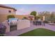 Outdoor entertaining area with a built-in bbq, stone fireplace, and seating at 8525 E Lynwood St, Mesa, AZ 85207