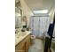 Bright bathroom with a skylight, a single-sink vanity, and a shower-tub combo with a stylish curtain at 8732 E Arlington Rd, Scottsdale, AZ 85250