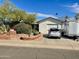 Charming home featuring a landscaped front yard with mature trees, a brick planter, and a well-maintained driveway at 8732 E Arlington Rd, Scottsdale, AZ 85250