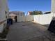 A concrete backyard with block walls on both sides, and garbage cans on the side at 9043 E Posada Ave, Mesa, AZ 85212