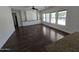 Open-concept living room with hardwood floors, built-in shelving, and large windows at 9043 E Posada Ave, Mesa, AZ 85212