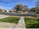 A peaceful neighborhood park with mature shade trees and a covered picnic area under a blue sky at 9043 E Posada Ave, Mesa, AZ 85212