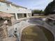 Large in-ground pool with a rock waterfall, slide, and a covered patio area near lawn at 9043 E Posada Ave, Mesa, AZ 85212