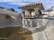 Exterior shot of an empty in-ground swimming pool with a covered patio and blue tile accents at 9043 E Posada Ave, Mesa, AZ 85212