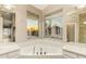 Bathroom featuring a soaking tub and double sinks in the vanity, plus a window with neighborhood views at 9812 E Karen Dr, Scottsdale, AZ 85260