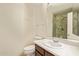 Bathroom with a stone-tile shower behind a glass door and a wood vanity at 9812 E Karen Dr, Scottsdale, AZ 85260