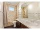 Tiled bathroom features a shower and tub, dual sinks, and a decorative mirror at 9812 E Karen Dr, Scottsdale, AZ 85260