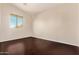 The empty bedroom has hardwood floors, a large window, and bright natural light at 9812 E Karen Dr, Scottsdale, AZ 85260