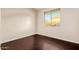 This empty bedroom features hardwood floors, a window, and neutral paint at 9812 E Karen Dr, Scottsdale, AZ 85260