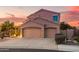 Two-story home with a three-car garage and desert landscaping at dusk at 9812 E Karen Dr, Scottsdale, AZ 85260