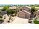 Exterior view of a home with desert landscaping and a three-car garage at 9812 E Karen Dr, Scottsdale, AZ 85260